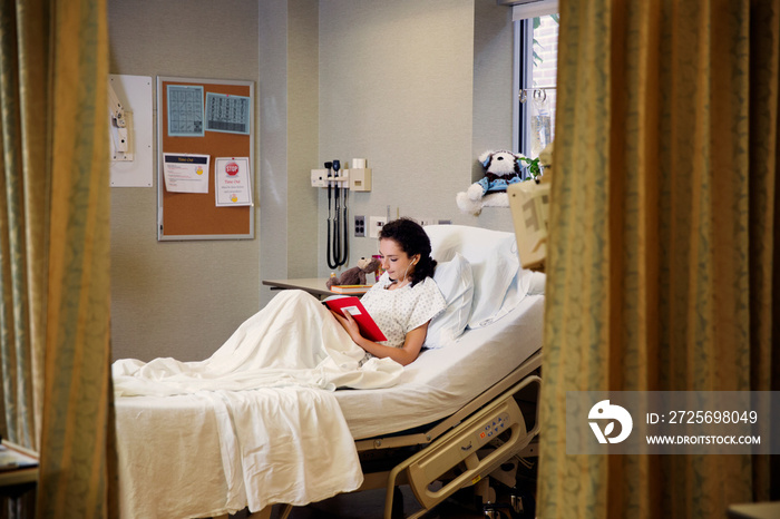 Patient reading book on hospital bed