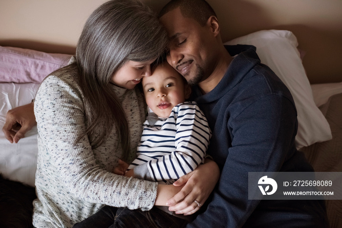 High angle view of parents with cute son relaxing on bed at home