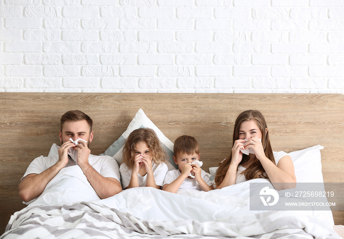 Family ill with flu in bed at home