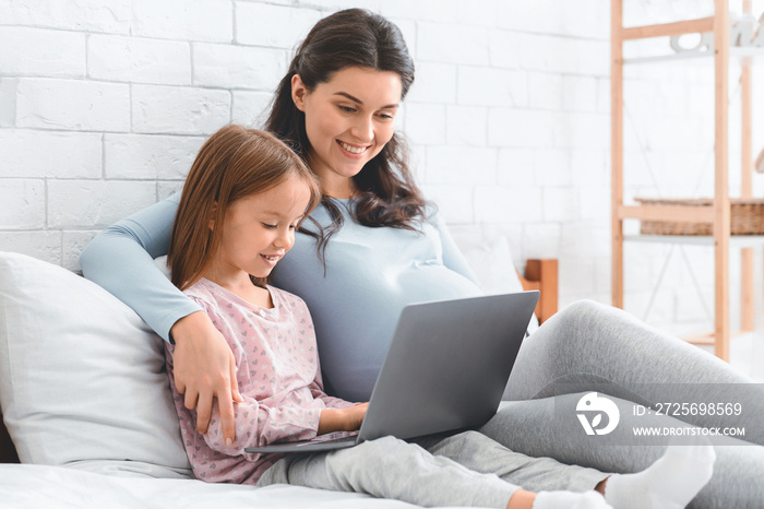 怀孕母亲教女儿如何使用笔记本电脑