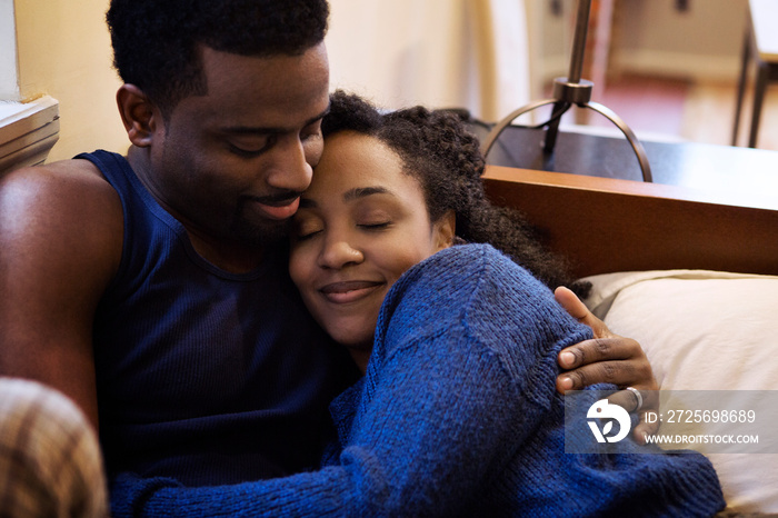 Couple hugging in bed