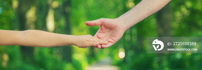 Father and child go holding hand. Selective focus.