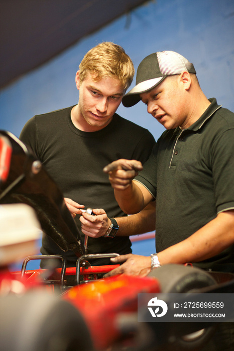 Mechanics in workshop repairing go cart