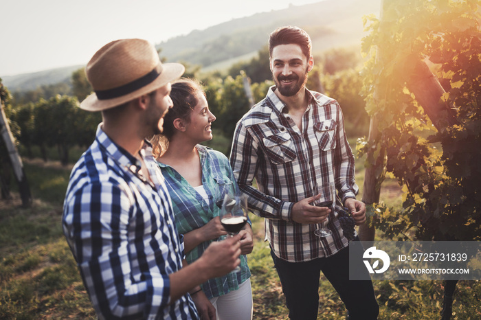 People sampling and tasting wines in vineyard