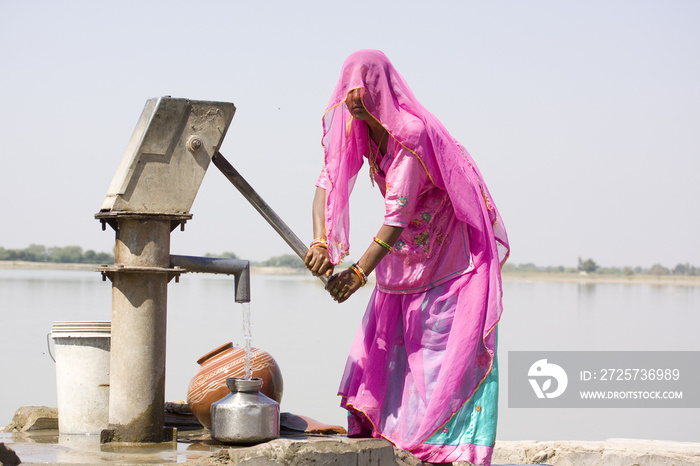 印度拉贾斯坦邦农村，一名女子在往饮用水里注水