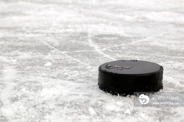 black hockey puck on ice rink