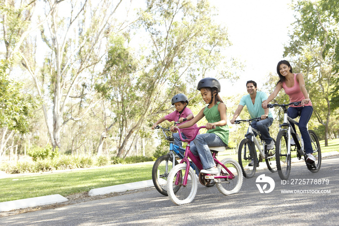 年轻的家庭在公园骑自行车