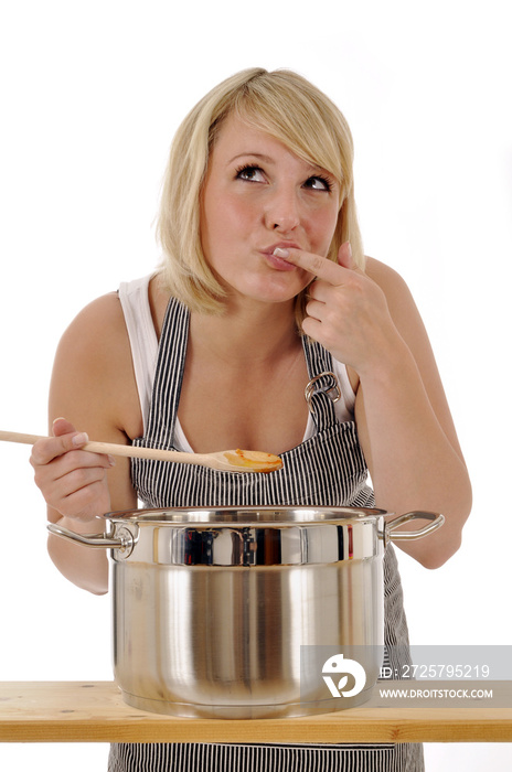 Junge Frau beim Kochen und Abschmecken