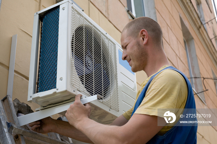 Young setup man installs the new air conditioner.