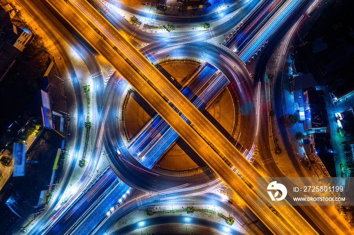 Aerial view of traffic in roundabout and highway at night.