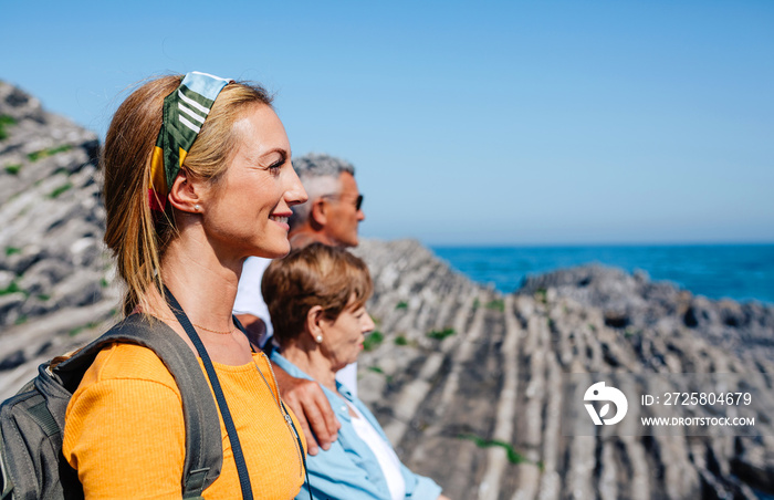 Adult woman hiking with her senior parents looking at the landscape