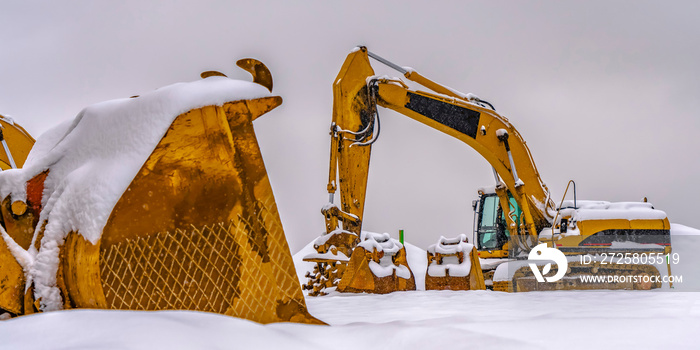 一辆亮黄色的建筑车在雪地里行驶