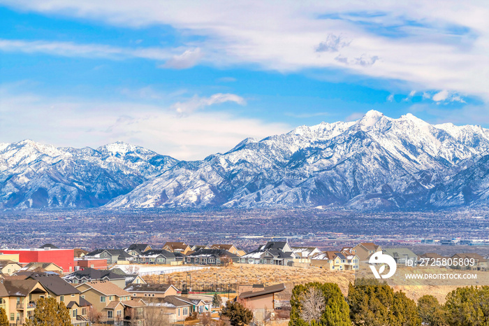 Magnificent snowy Wasatch Mountain towering over a neighborhood and valley