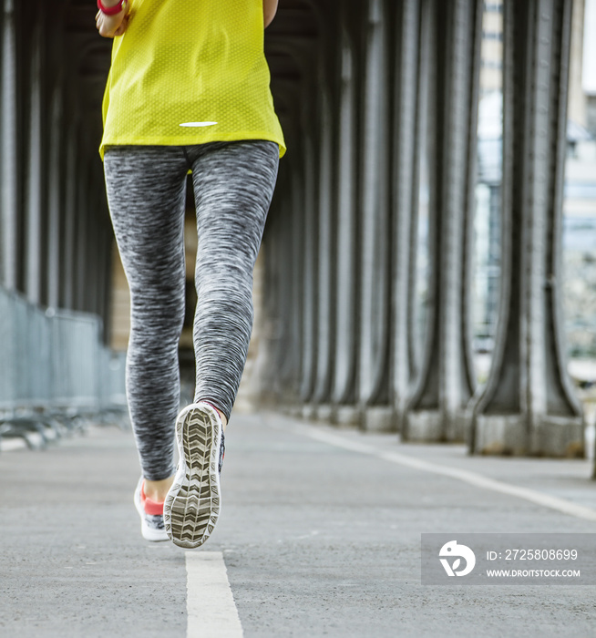 Closeup on woman jogger running on Pont de Bir-Hakeim bridge