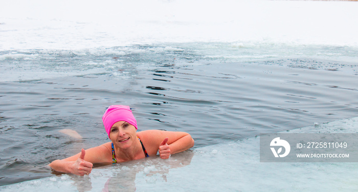 戴粉色帽子的女人，极限冬泳，冬天在霜冻中在冰水中游泳