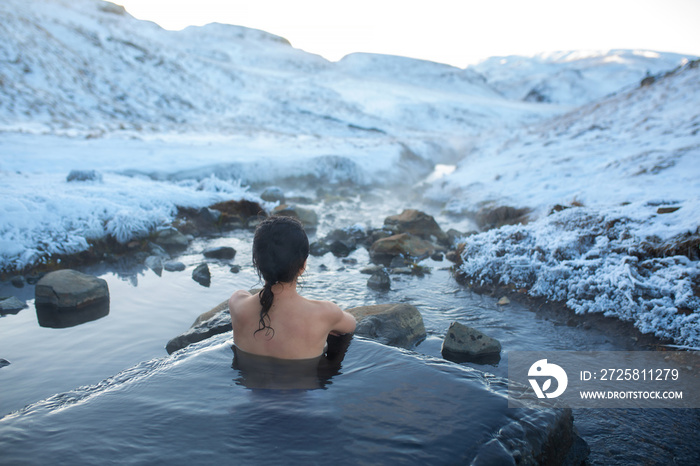 女孩在露天的温泉里沐浴，可以欣赏到雪山的壮丽景色。不可思议