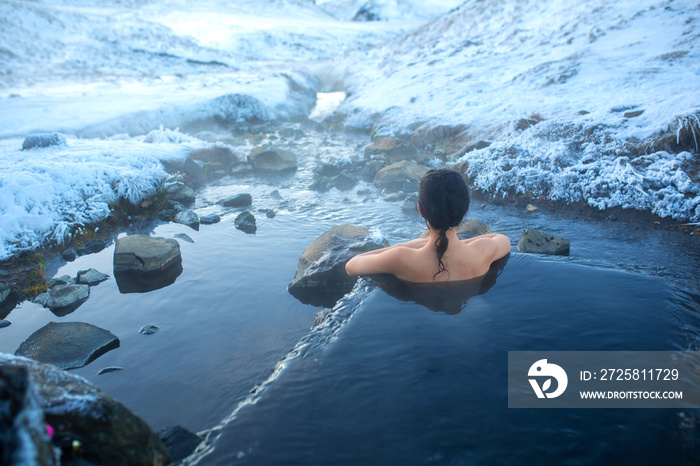 女孩在露天的温泉里沐浴，可以欣赏到雪山的壮丽景色。不可思议