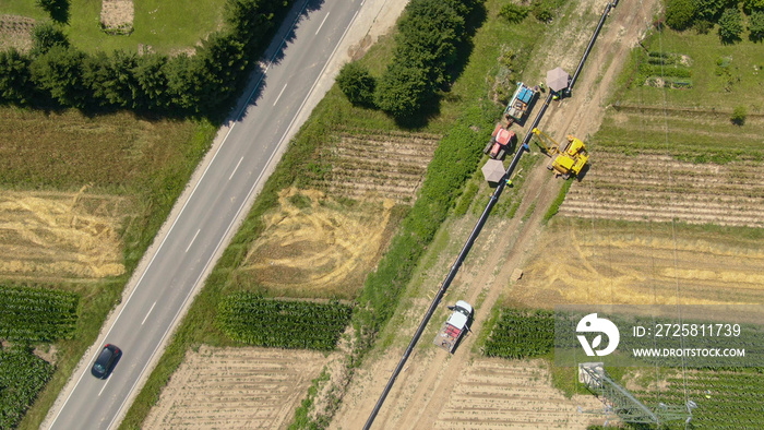 TOP DOWN: Flying above a long line of unassembled gas pipes laid along a road