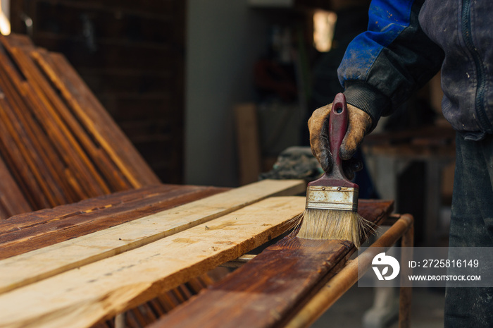 Varnishing a wooden plank using paintbrush