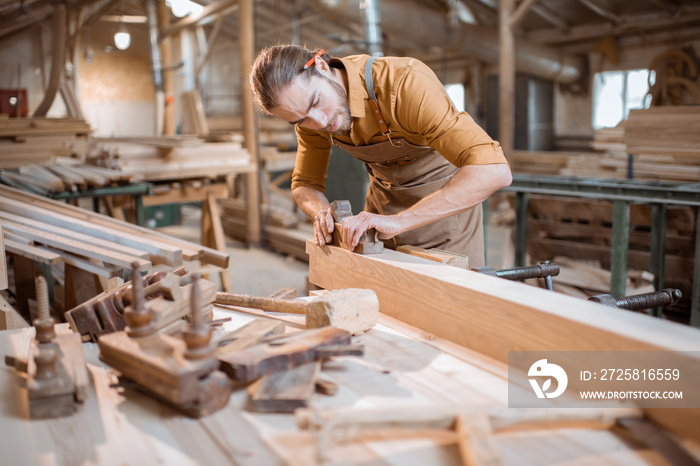 Carpenter working with a wood in the workshop