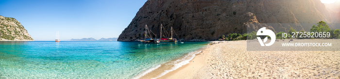 Sailing ships moored in a secluded bay with turquoise water and empty beach at sunrise, Oludeniz, Tu