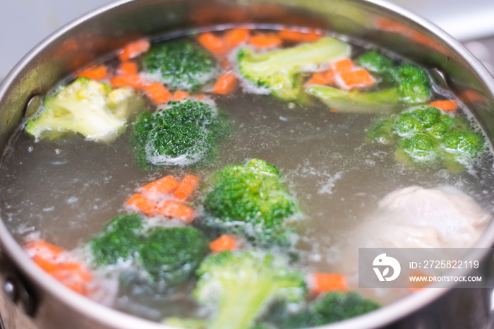 boiling soup in the pan. broccoli, carrots, potatoes, chicken