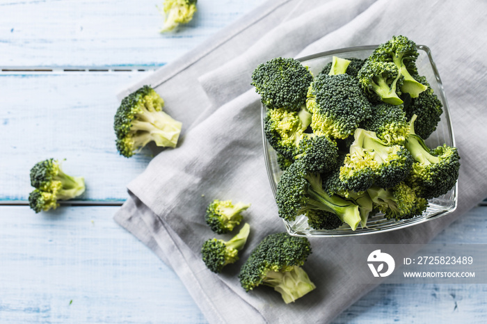 Fresh broccoli in bowl on kitchen table