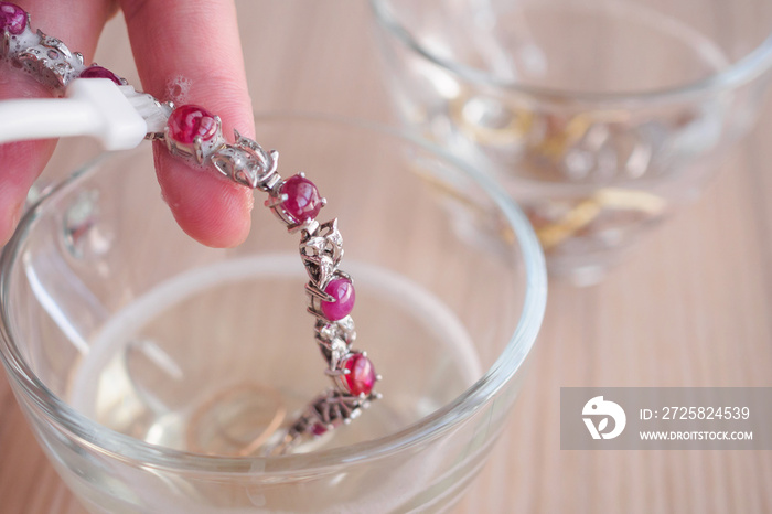 Jeweller hand cleaning and polishing vintage jewelry red ruby bracelet closeup