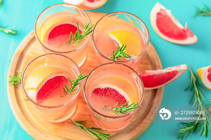 Fresh pink alcoholic cocktail with grapefruit, ice and rosemary