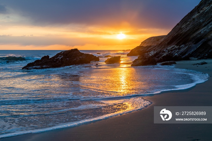 Breathtaking sunset over the ocean and the rocks on the beach captured in California, USA