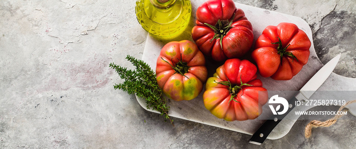 砧板上的白兰地番茄横幅。用新鲜橄榄油和百里香烹饪夏季沙拉。on