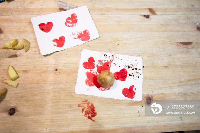 Carving potato. potatoes, colored ink, knives and paper on a wooden table to make stamps with potato