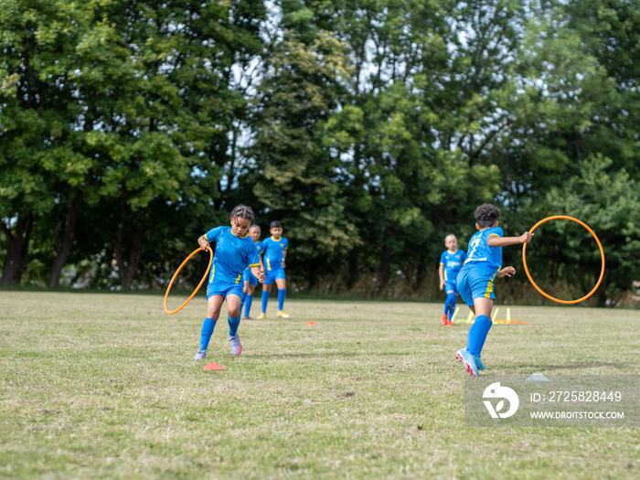 儿童（8-9岁）穿着制服在足球场上练习