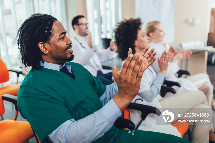 Group of happy doctors on seminar in lecture hall at hospital