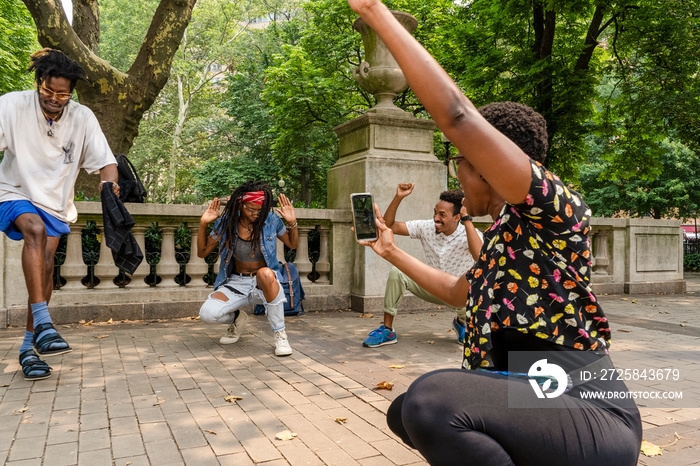 Playful friends in park photographing self with smart phone