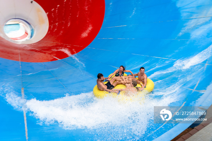 Frinds on big colorful water slide at aquapark