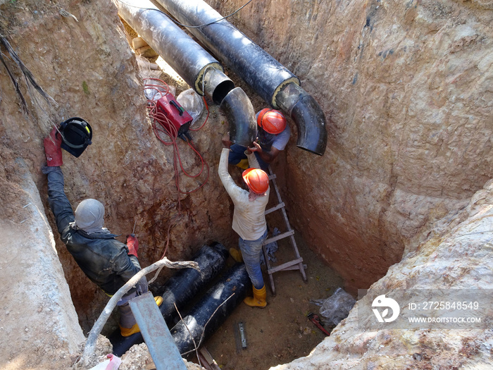 建筑工人冒着生命危险在深沟中工作，安装地下服务