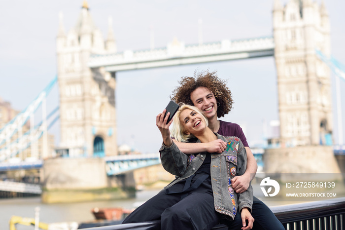 Happy couple taking selfie photograph at the Tower Bridge