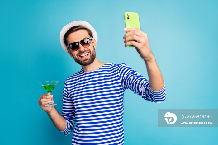 干杯。时髦的旅行者在博客电话自拍，喝绿色鸡尾酒全包的照片