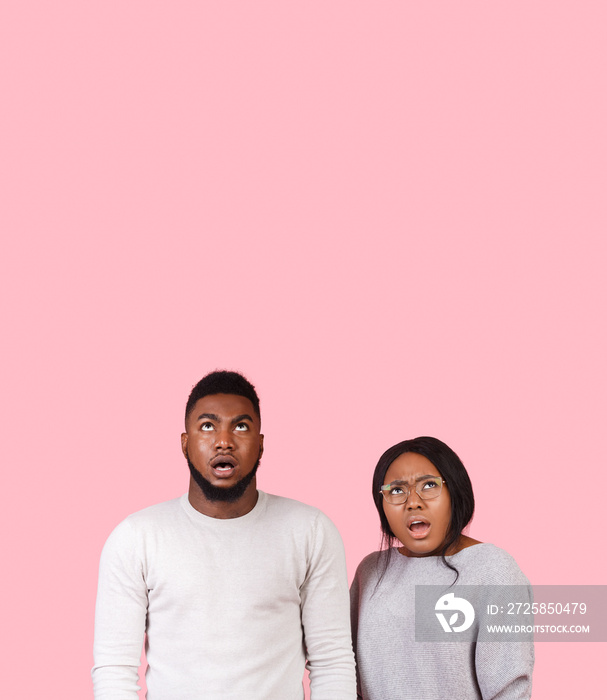 Stunned afro couple looking up at copy space