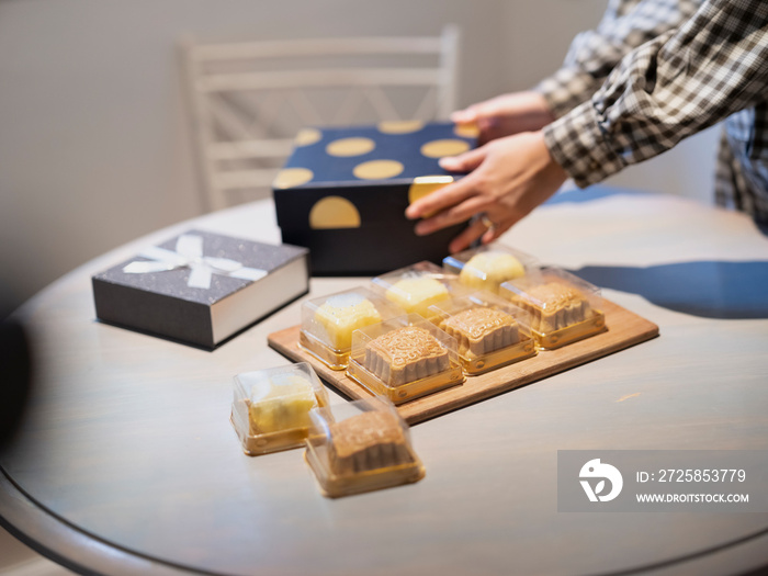 Woman preparing gift boxes with moon cakes