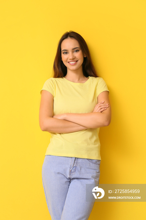 穿着黄色背景时尚t恤的漂亮年轻女人