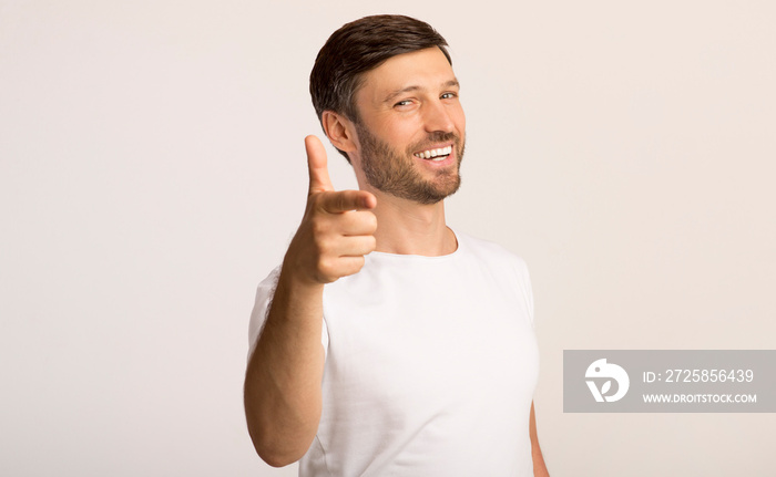 Guy pointing finger at camera standing on white background