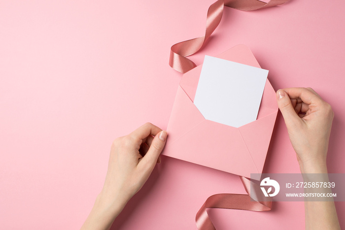 First person top view photo of valentines day decorations female hands holding open pink envelope w