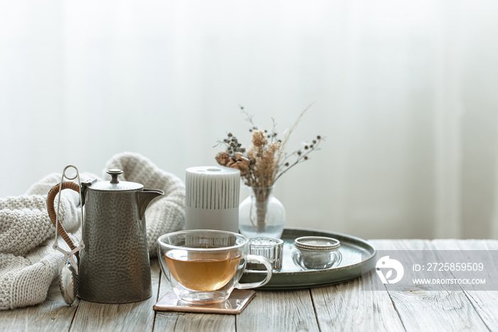 一杯茶、茶壶和斯堪的纳维亚装饰细节的舒适家居组合。