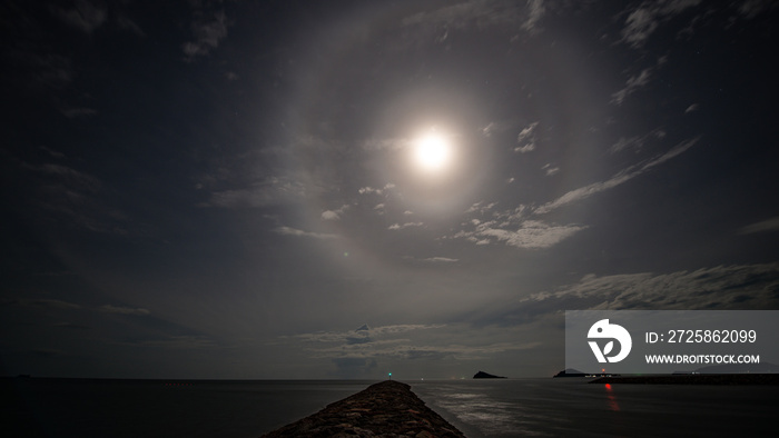 stunning beautiful big lunar ring and bright moon in little cloudy sky night floating over seascape 
