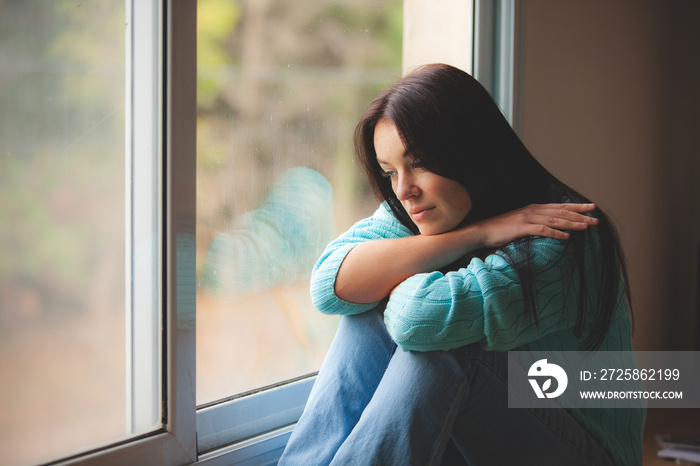 woman sitting on the window sill