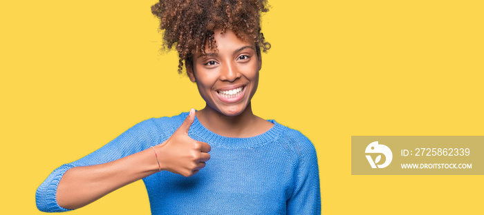 Beautiful young african american woman over isolated background doing happy thumbs up gesture with h