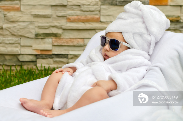 Bebé relajado disfrutando en sesión de spa al aire libre.