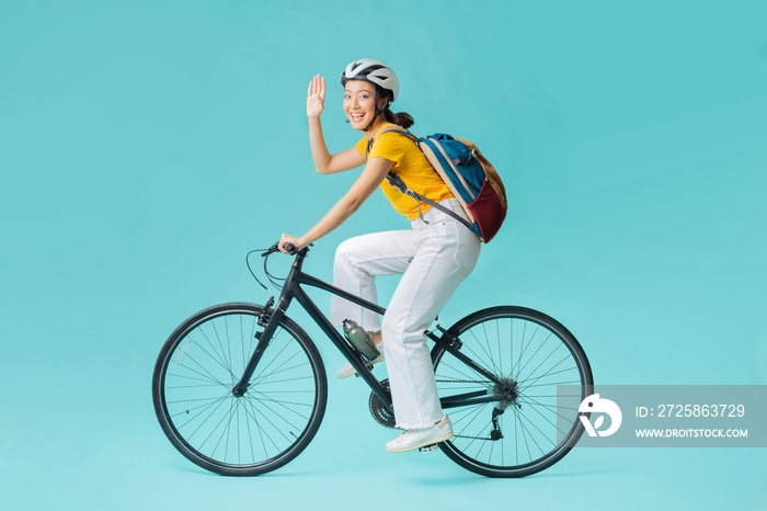 Asian beautiful woman, she is riding a city bike to work.She is greeting.